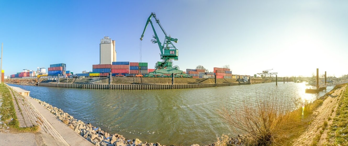 Kran an einem Hafen verlädt farbige Container