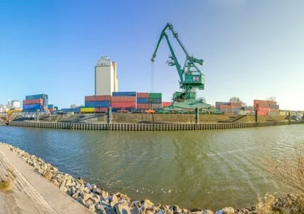 Kran an einem Hafen verlädt farbige Container