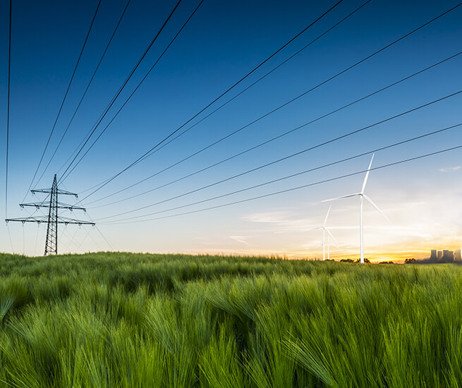 enformer Energiewende grüne Feldlandschaft Stommast Windkraftanlage Kohlekraftwerk im Hintergund 