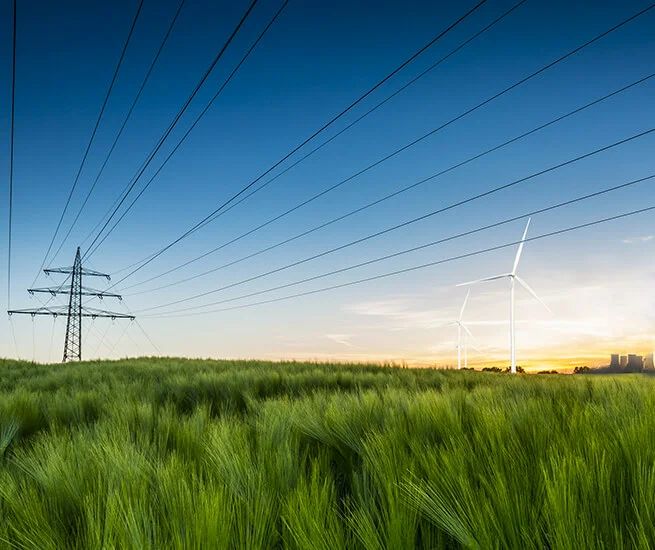 enformer Energiewende grüne Feldlandschaft Stommast Windkraftanlage Kohlekraftwerk im Hintergund 