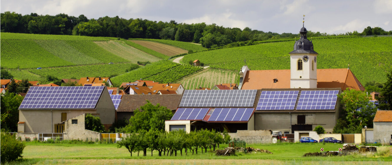 Energiewende im enformer Stimmungsbild Dorf mit Solardächern in hügeliger Feldlandschaft