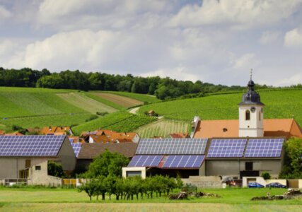 Energiewende im enformer Stimmungsbild Dorf mit Solardächern in hügeliger Feldlandschaft