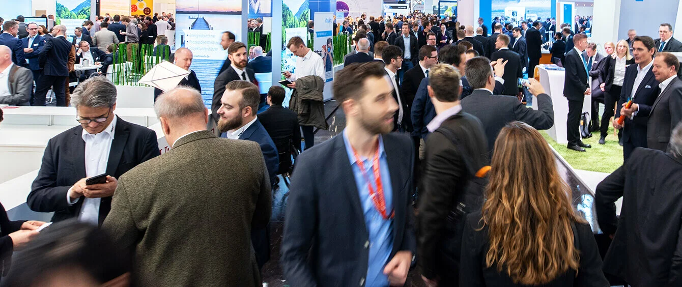 Geschäftiges Treiben von Menschen auf einer Messe für die Zukunft der Energie