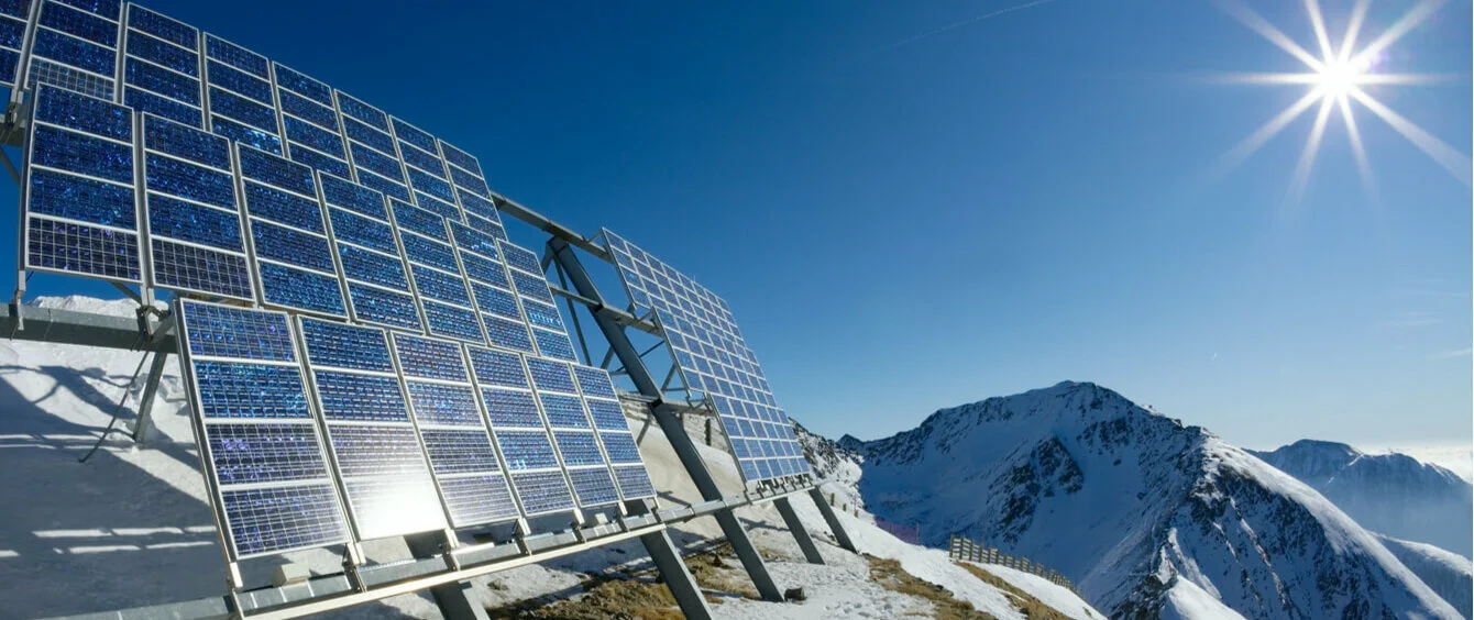 Solarpanele oben auf einem schneebedeckten Berggipfel