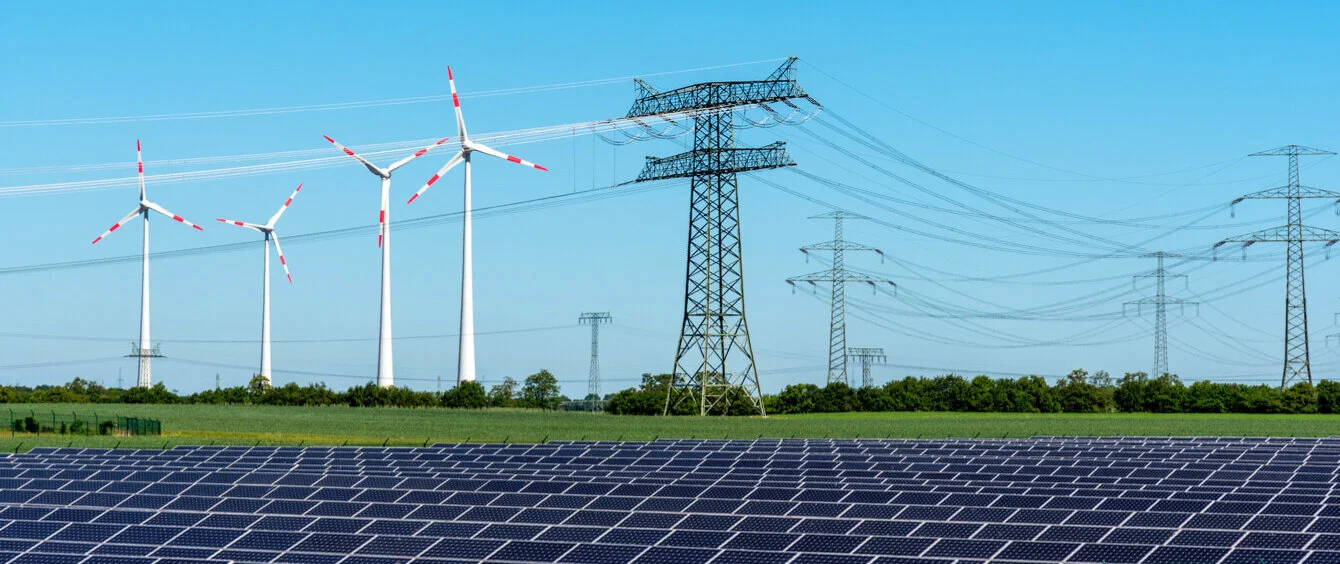 Solaranlagen und Windräder als Erneuerbare Energien in Verbindung mit Stromleitungen zum Weitertransport