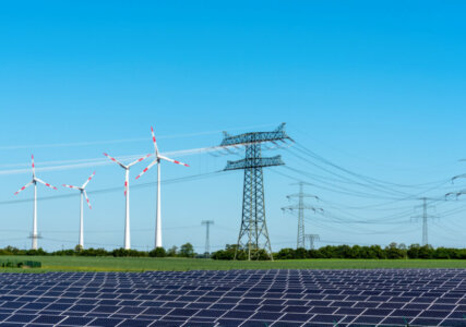 Solaranlagen und Windräder als Erneuerbare Energien in Verbindung mit Stromleitungen zum Weitertransport