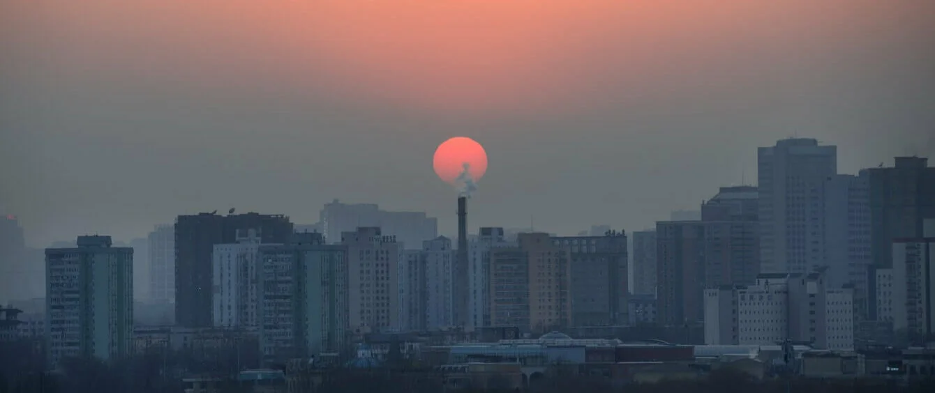 Chinesische Stadt in Smog vor Sonnenuntergang