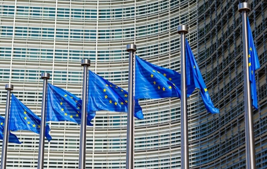 Blaue Europafahnen in Reihe vor dem EU-Parlament