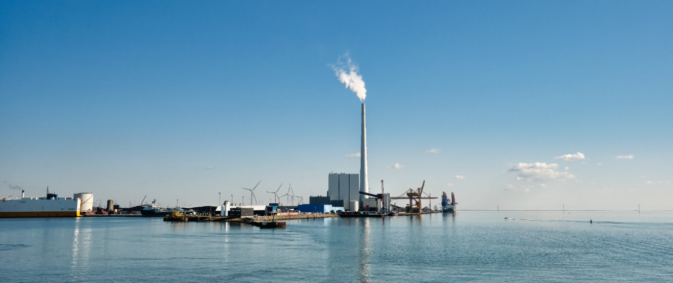 Foto zeigt Hafen von Esbjerg in Dänemark mit Kohlekraftwerk und Windturbinen im Hintergrund