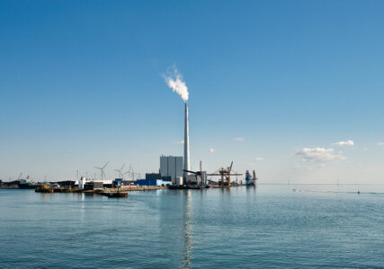 Foto zeigt Hafen von Esbjerg in Dänemark mit Kohlekraftwerk und Windturbinen im Hintergrund