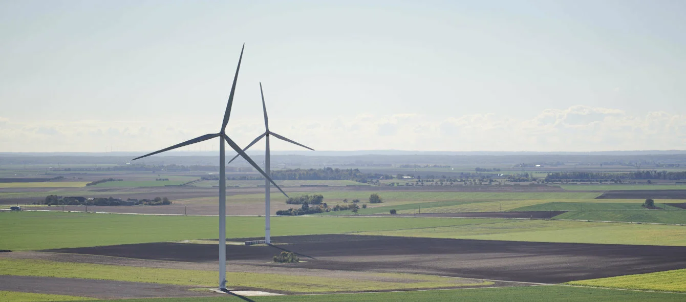 Foto, das eine Landschaft mit Windrädern zeigt
