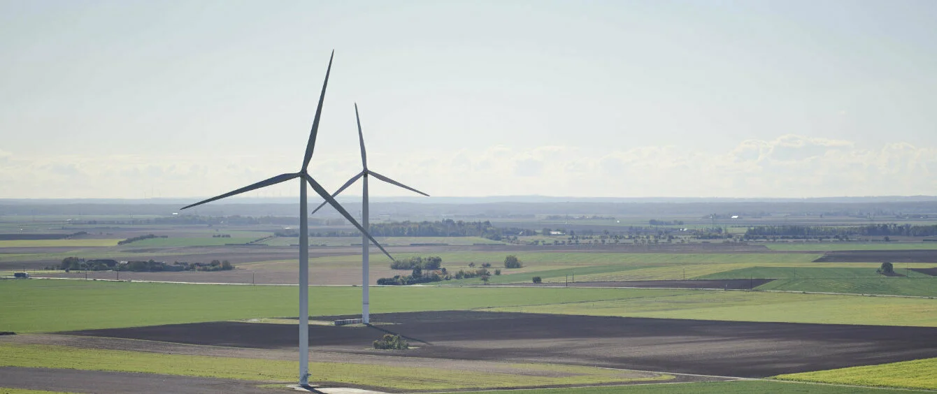 Foto, das eine Landschaft mit Windrädern zeigt